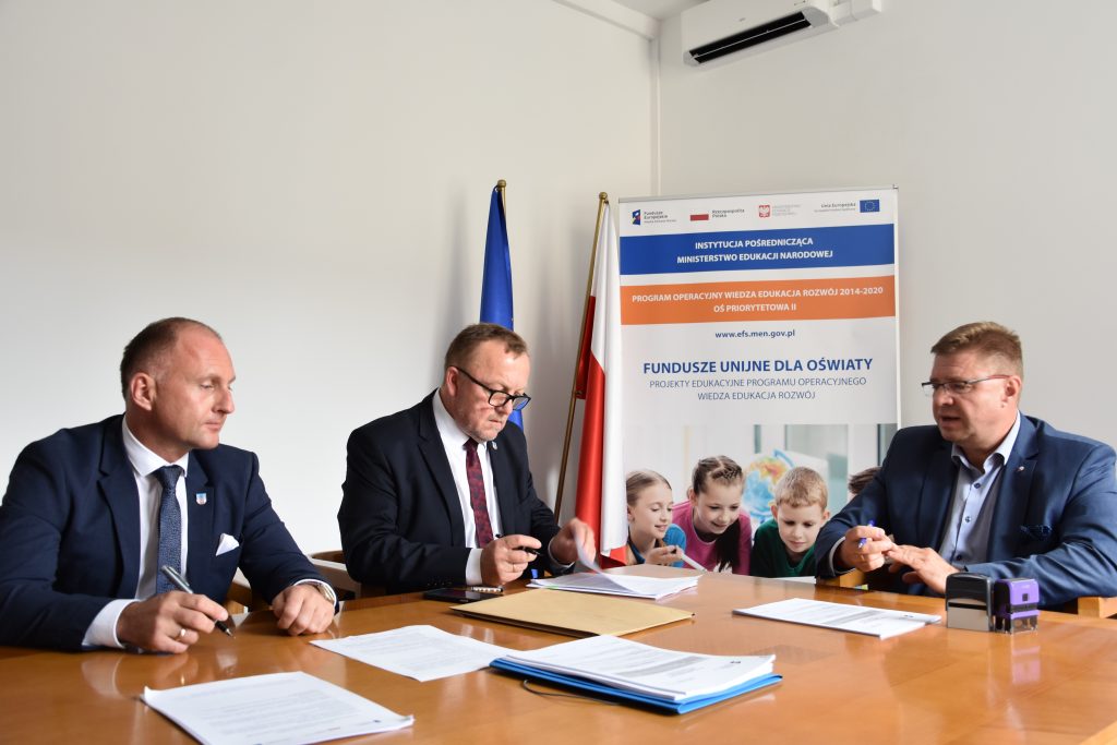 Podpisanie umowy. Na zdjęciu przy stole siedzą trzy osoby: dwóch przedstawicieli Powiatu Jarosławskiego i Zastępca Dyrektora Departamentu Funduszy Strukturalnych. Rozmawiają i podpisują dokumenty