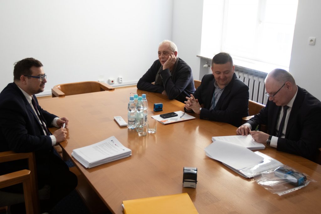 Podpisanie umowy: na zdjęciu przy stole siedzi trzech przedstawicieli Instytutu Badan Edukacyjnych i Dyrektor Departamentu Funduszy strukturalnych. Rozmawiają i podpisują dokumenty